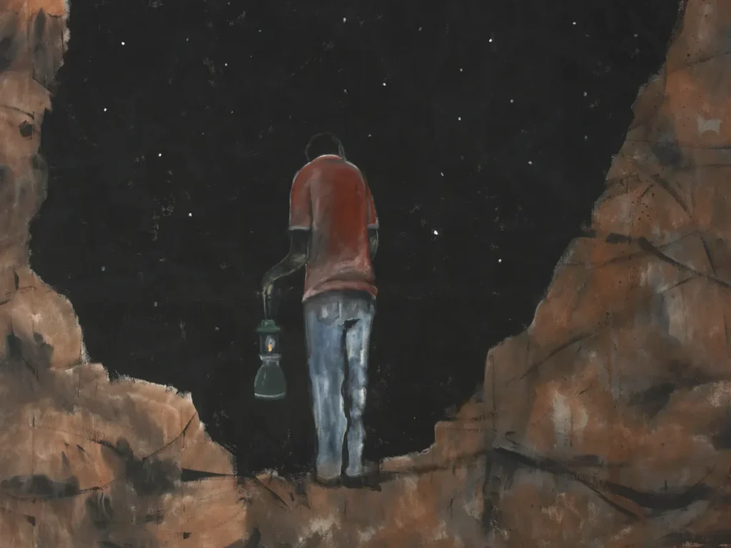 Pessoa parada em silêncio, postura estável, iluminada por luz suave, representando sustentação e presença.