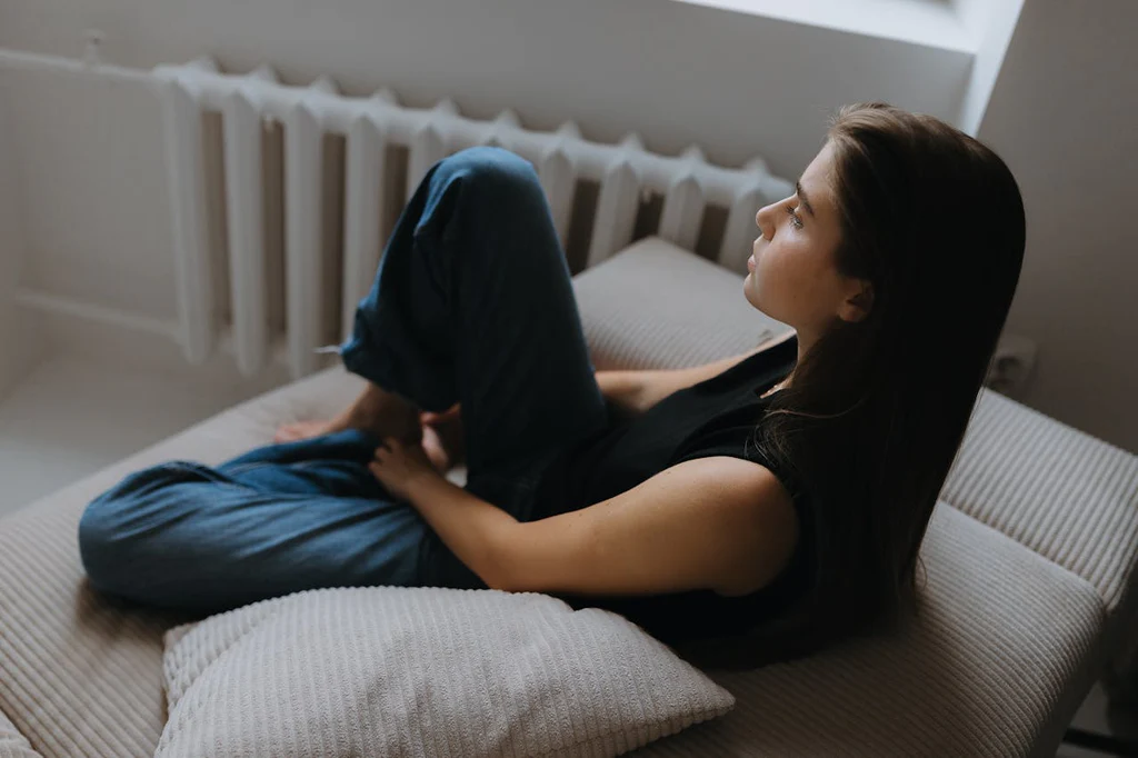 Pessoa sentada em silêncio, presença tranquila sob luz suave, representando estar sem definir ou rotular.